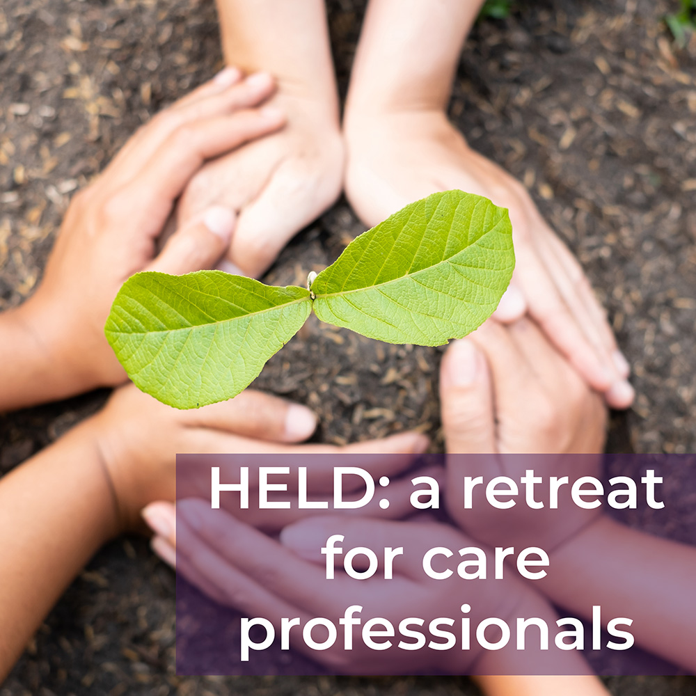 Hands around a sapling with the text, "Held: a retreat for care professionals"